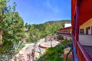 A courtyard with a circular seating area, surrounded by trees and a building with red accents. - Hotel Spa Villalba (Vilaflor)