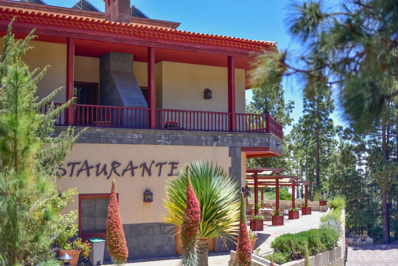 A restaurant with a red roof and a balcony.