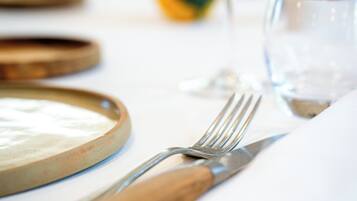 A table set with a plate, fork, knife, and glass.