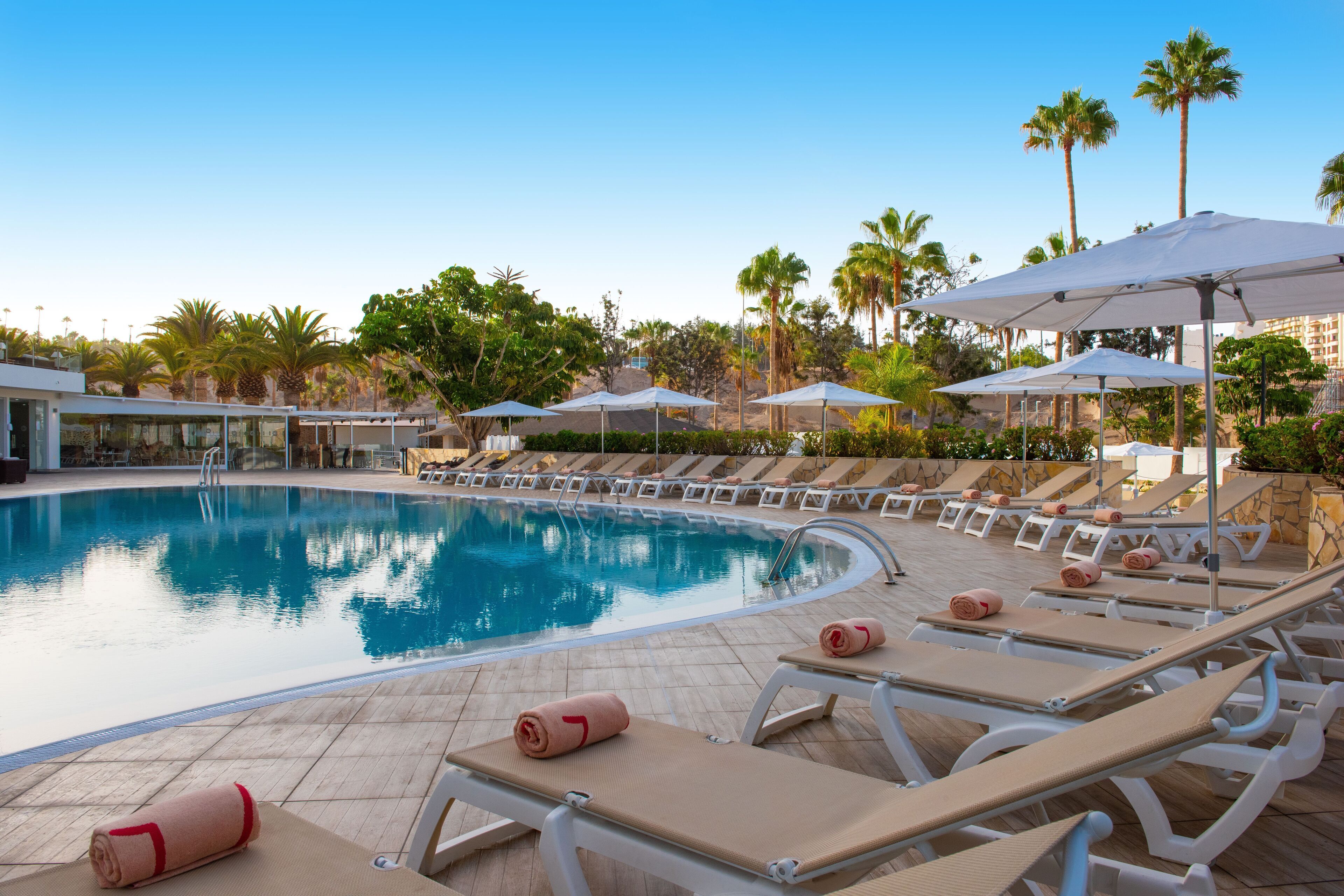 Piscine extérieure, parasols de plage, chaises longues