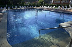 Una piscina techada, una piscina al aire libre de temporada, sombrillas