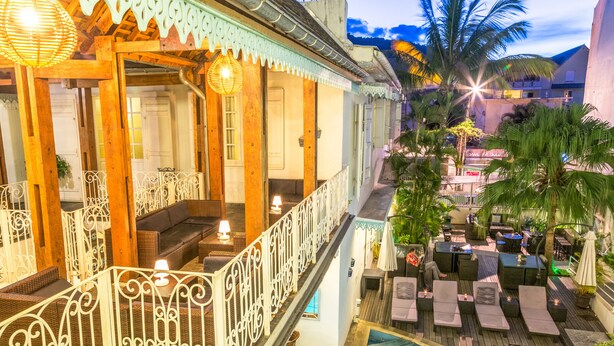 A rooftop pool area with a hot tub, lounge chairs, and a covered seating area with a staircase leading to the upper level. - Hotel le Juliette Dodu (Saint-Denis)