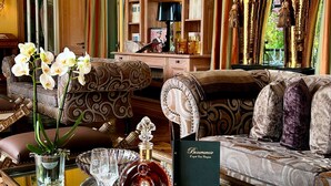 A well-appointed living room with a large bookshelf, a sofa, and decorative glassware. - Beaumanoir Small Luxury Boutique Hotel (Biarritz)