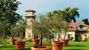 A building with a tower, surrounded by potted plants and greenery. - Beaumanoir Small Luxury Boutique Hotel (Biarritz)