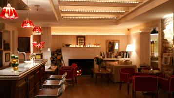 A warmly lit interior with a bar area, seating, and a fireplace.