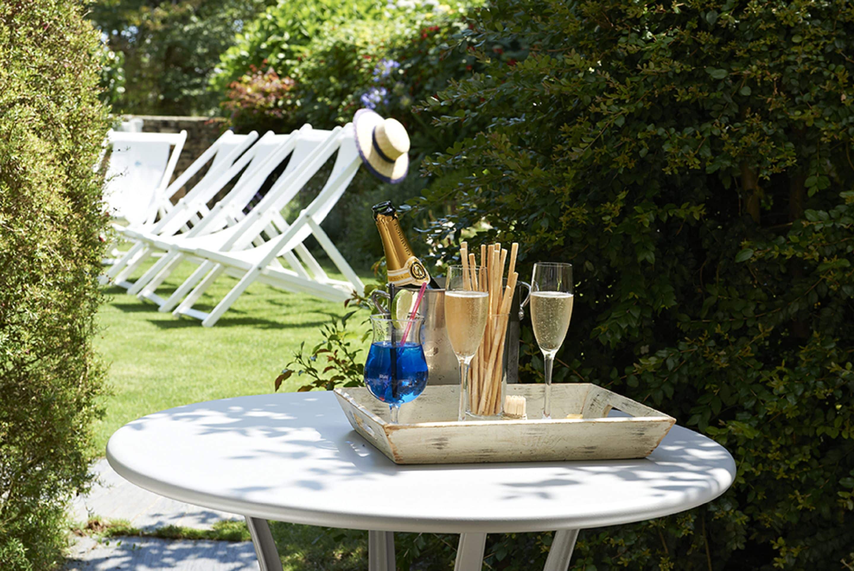 A round table with a tray containing a bottle of champagne, glasses, and a blue drink.