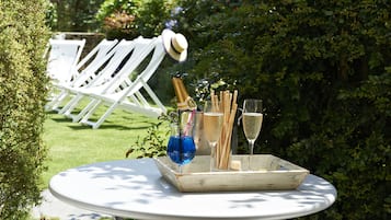 A round table with a tray containing a bottle of champagne, glasses, and a blue drink.