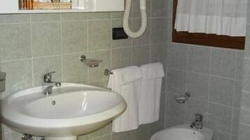 Ein Badezimmer mit einem Standwaschbecken, einer Toilette und einem Bidet.