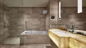A modern bathroom with a glass-enclosed shower, a freestanding bathtub, and a vanity with a double sink.