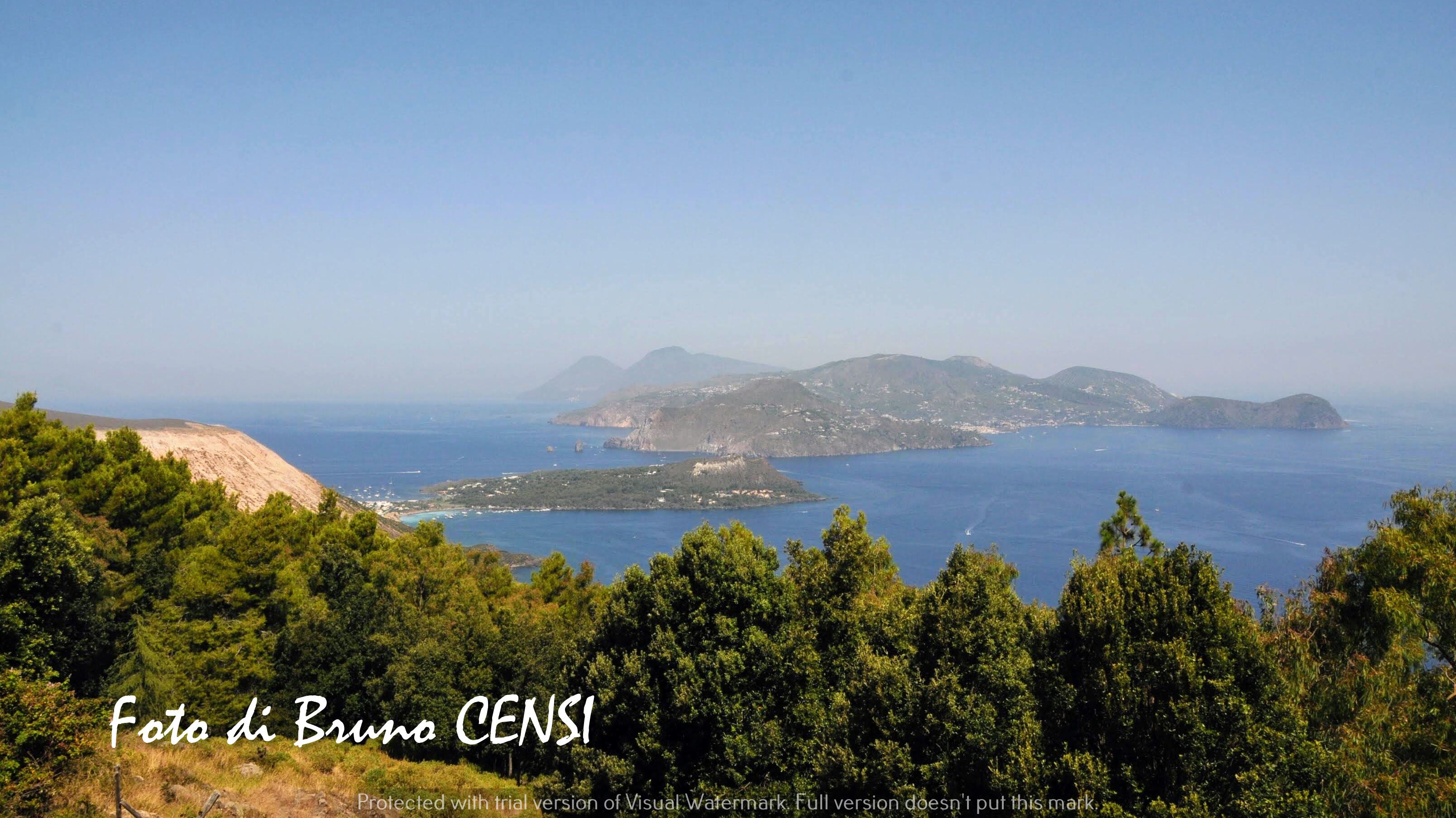 Paisagem costeira com vista ampla para o mar, colinas e vegetação densa.