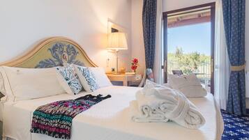 Quarto de hotel com cama, mesa de cabeceira, luminária e vista para o exterior.