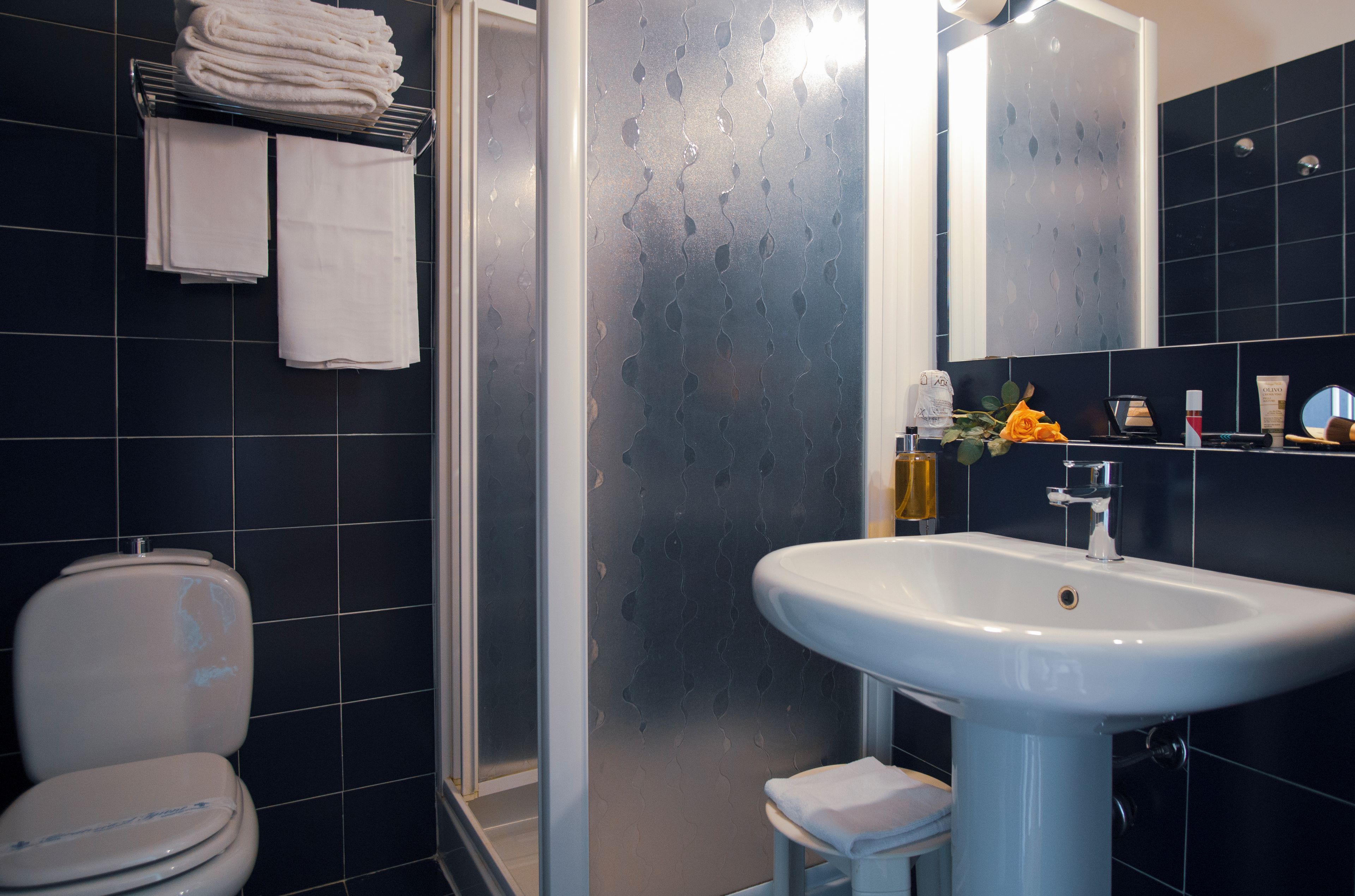 A bathroom with a white sink, a toilet, and a glass shower enclosure.