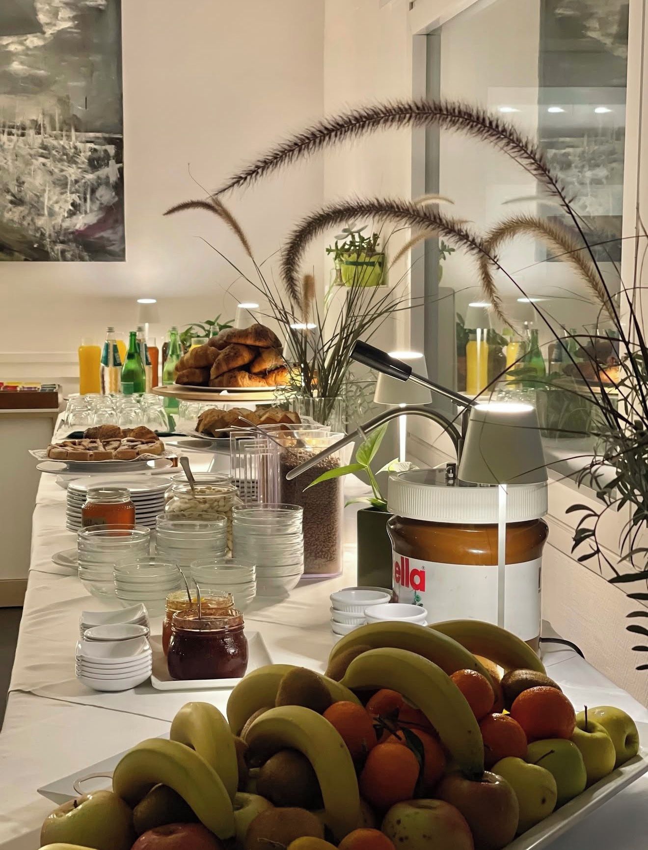 Una mesa de buffet con diversos alimentos, entre ellos frutas, pasteles y salsas.
