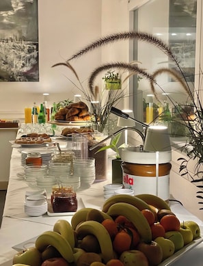 A buffet table with various food items, including fruits, pastries, and condiments. - Hotel Mistral 2 (Oristano)