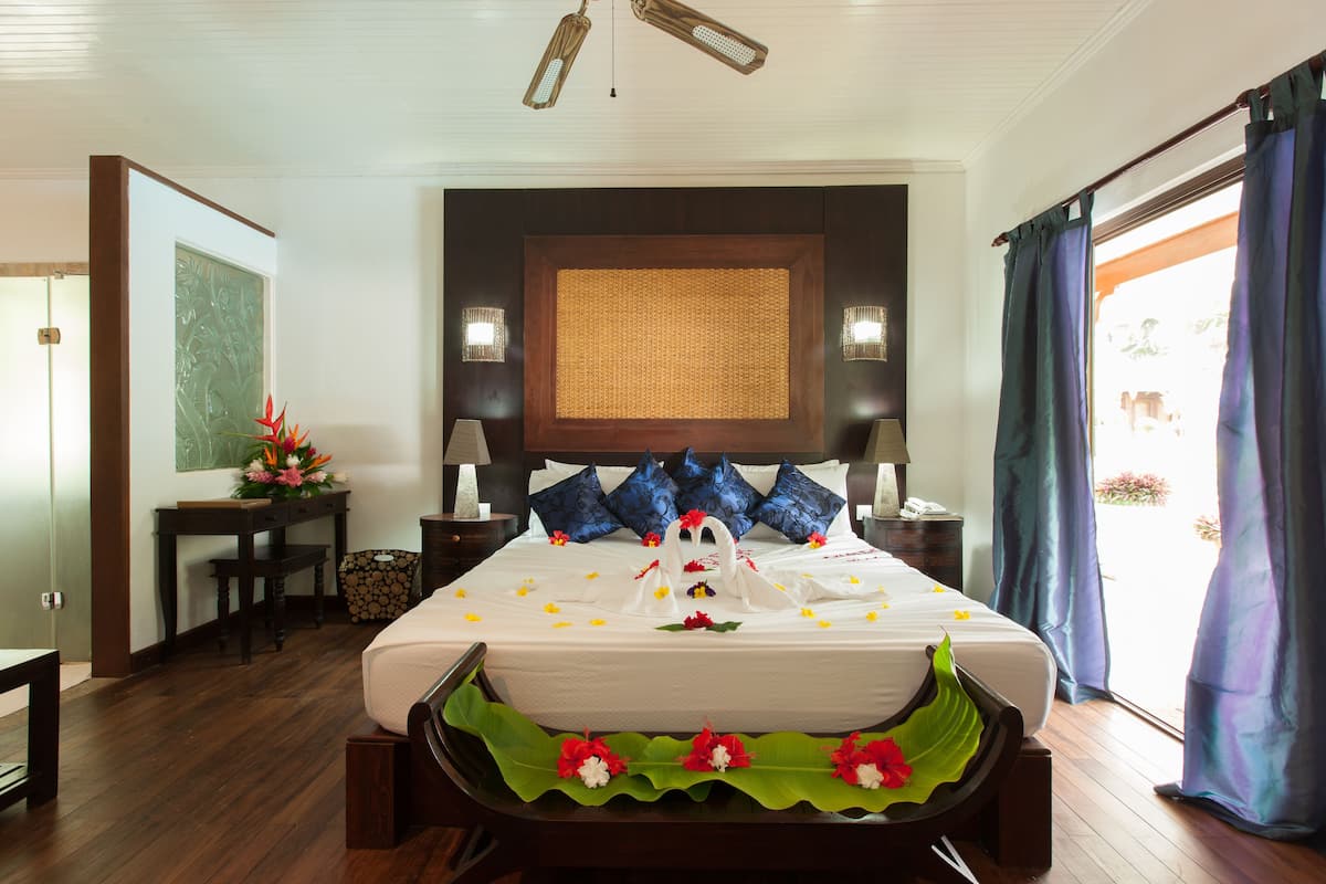 Quarto de hotel bem arrumado, com uma cama grande, uma mesa de trabalho e vista para o exterior.