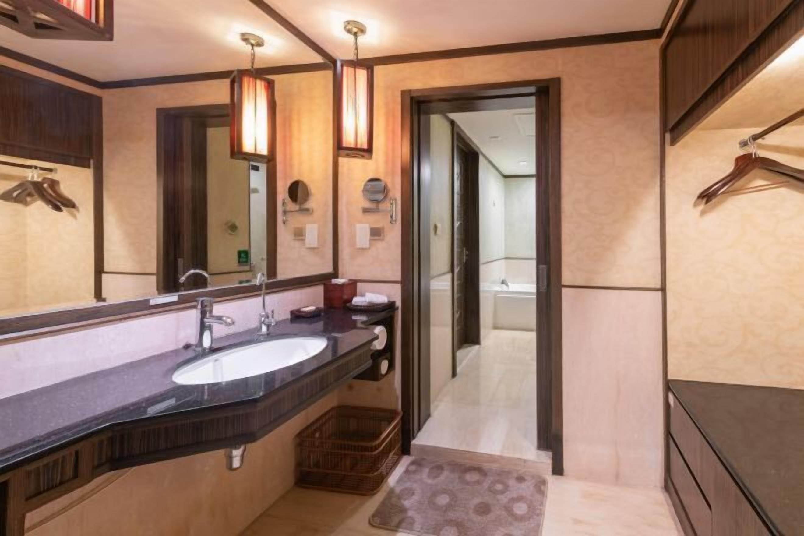 Ein modernes Badezimmer mit einem großen Spiegel, einem Waschbecken und einer Duschkabine.