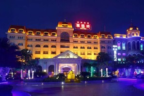 A large hotel with a prominent entrance, multiple floors, and a well-lit facade. - Mascot Hotel (Zhongshan)