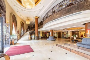 A grand lobby with a marble floor, a staircase, and a balcony. - Mascot Hotel (Zhongshan)