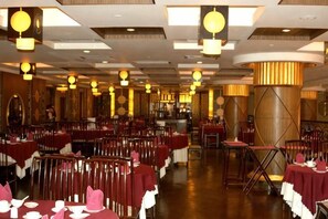 A restaurant with multiple tables, chairs, and hanging spherical light fixtures. - Mascot Hotel (Zhongshan)