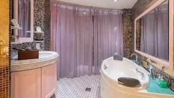 Ein Badezimmer mit einer weißen Badewanne, einem Waschtisch mit Spiegel und einer Duschvorhang.
