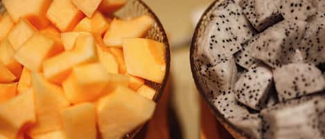 Two bowls of fruit, one with diced melon and the other with dragon fruit.