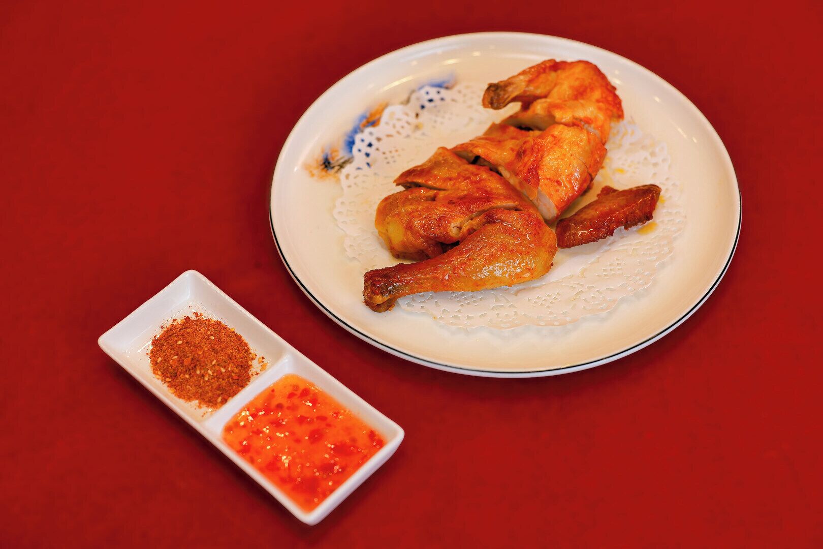 Un piatto di pollo arrosto con salsa rossa e un mix di spezie.
