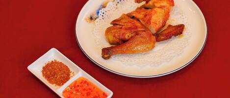 Un piatto di pollo arrosto con salsa rossa e un mix di spezie.