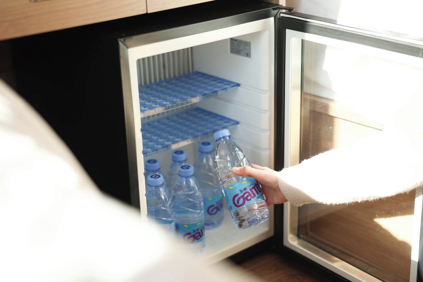 Een koelkast met een hand die een fles Gatorade vasthoudt.