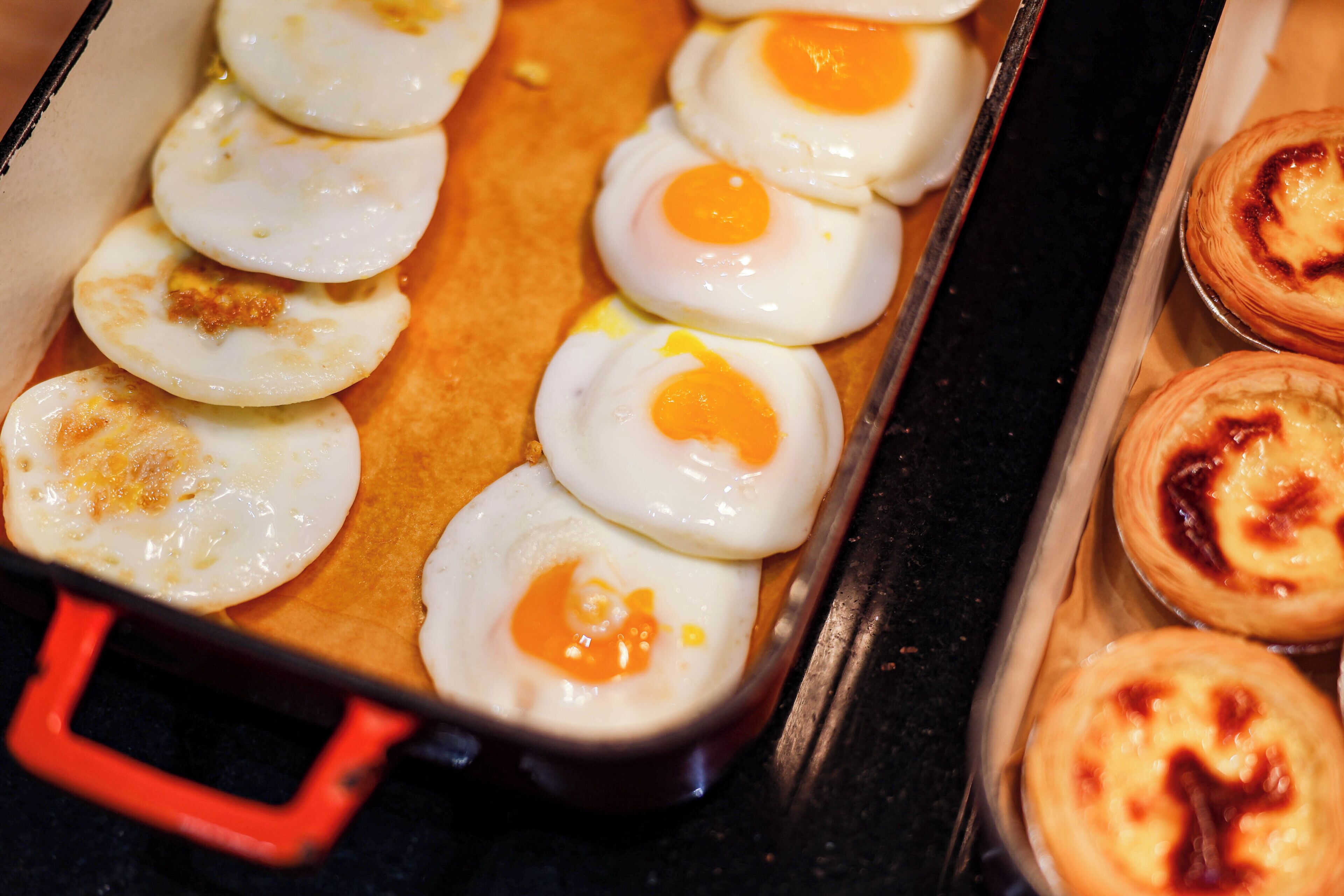 A baking tray with eggs and pastries.