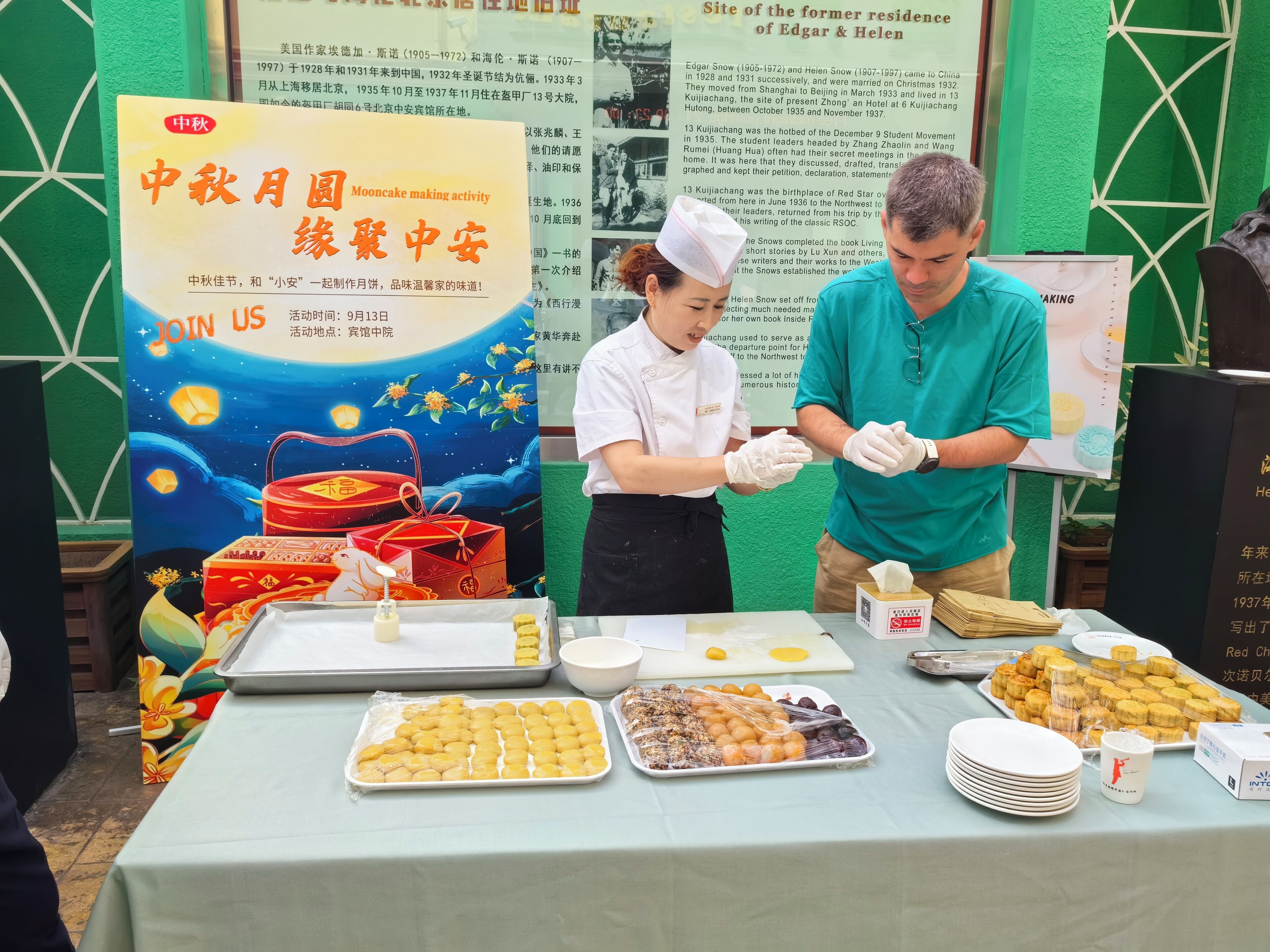 A table with various food items and a poster with text in a foreign language.