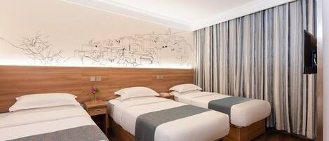 Habitación de hotel con tres camas, cabecera de madera, un mural en la pared, televisor de pantalla plana y una cortina.