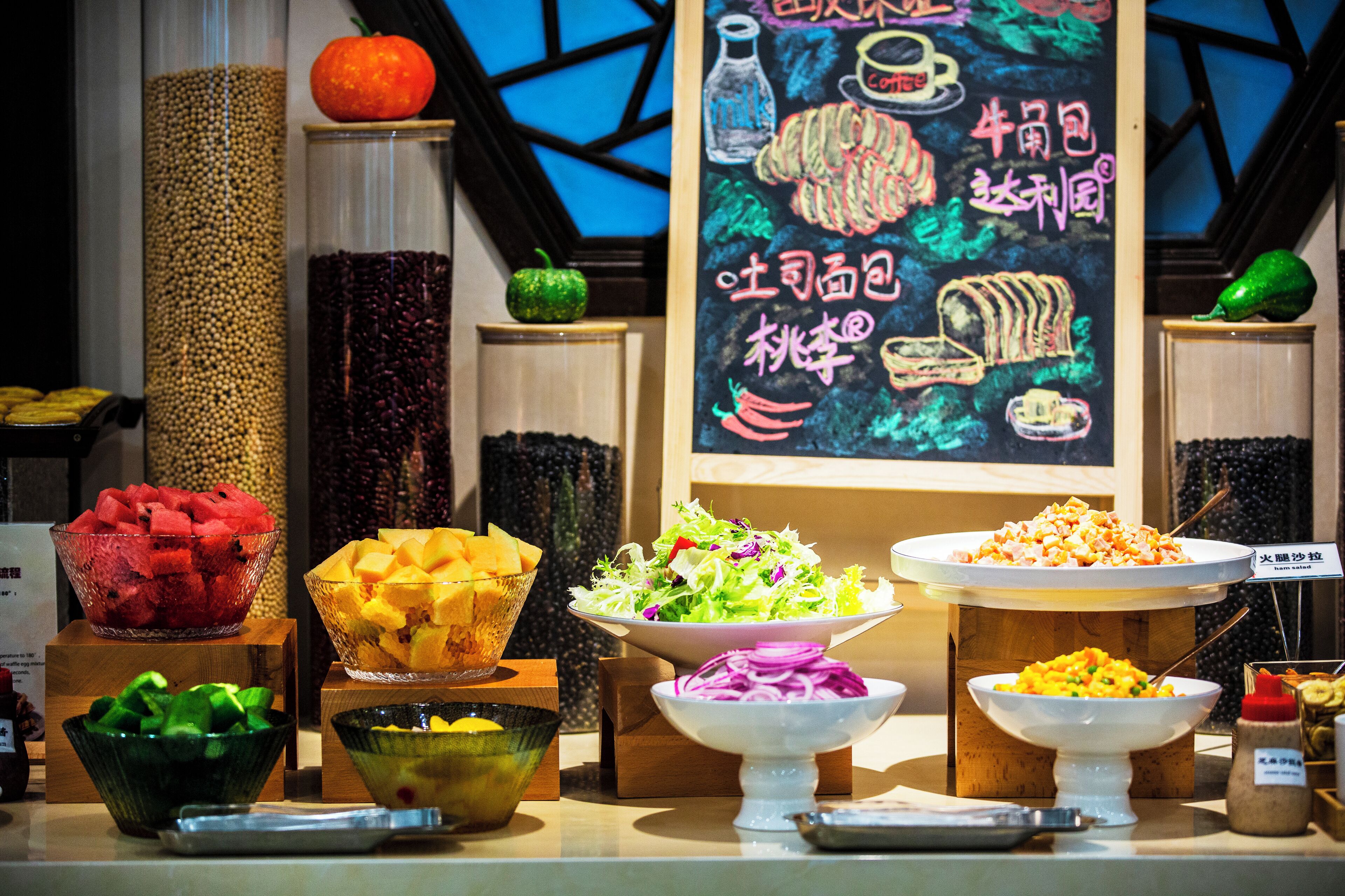 A buffet with various food items and a chalkboard menu in the background.