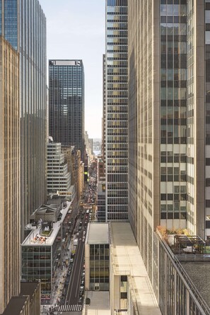 A high-rise urban area with modern buildings, a busy street, and a pedestrian walkway. - DoubleTree by Hilton New York Midtown Fifth Ave (New York)