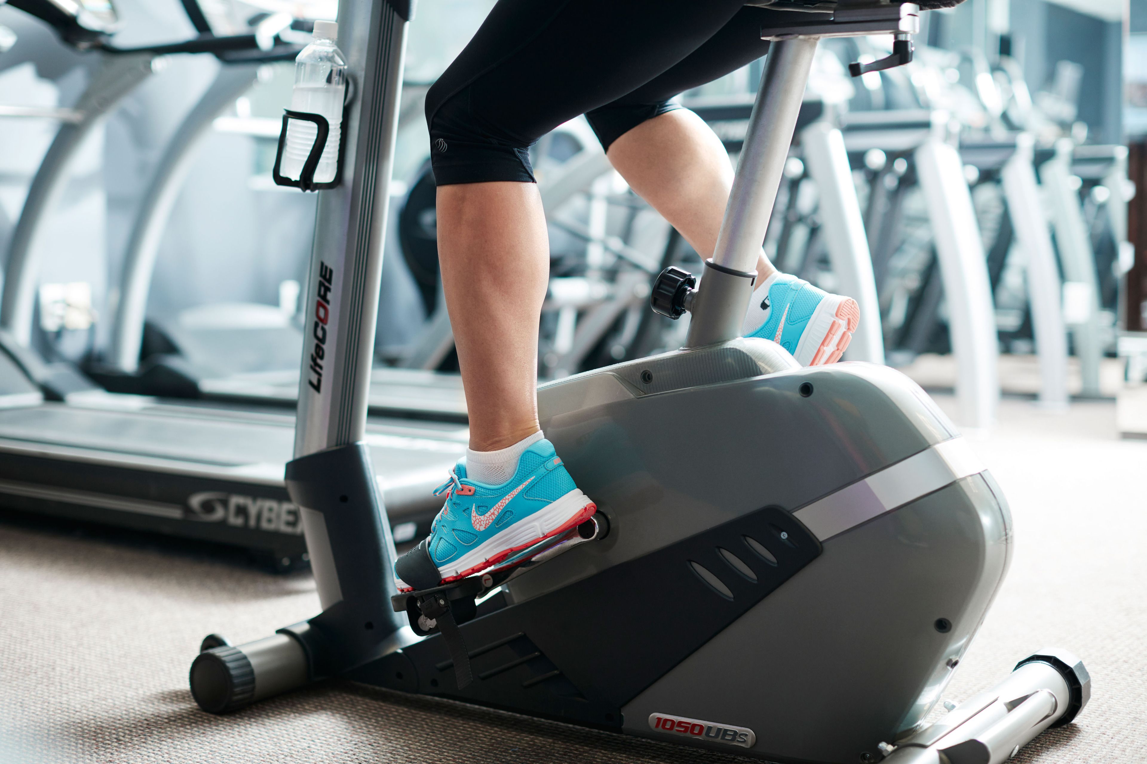 A person using an exercise bike with a visible brand name and a control panel.