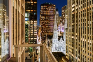 A nighttime cityscape with modern high-rise buildings and a historic cathedral with intricate architecture. - DoubleTree by Hilton New York Midtown Fifth Ave (New York)