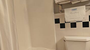 Une salle de bain équipée d’une baignoire, de toilettes et d’un porte-serviettes avec des serviettes pliées.