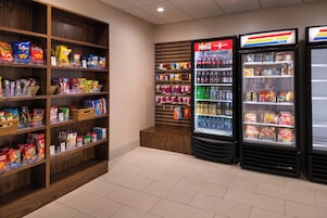 Un área de venta automática con aperitivos y bebidas, que ofrece varias opciones de bocadillos y bebidas refrigeradas.