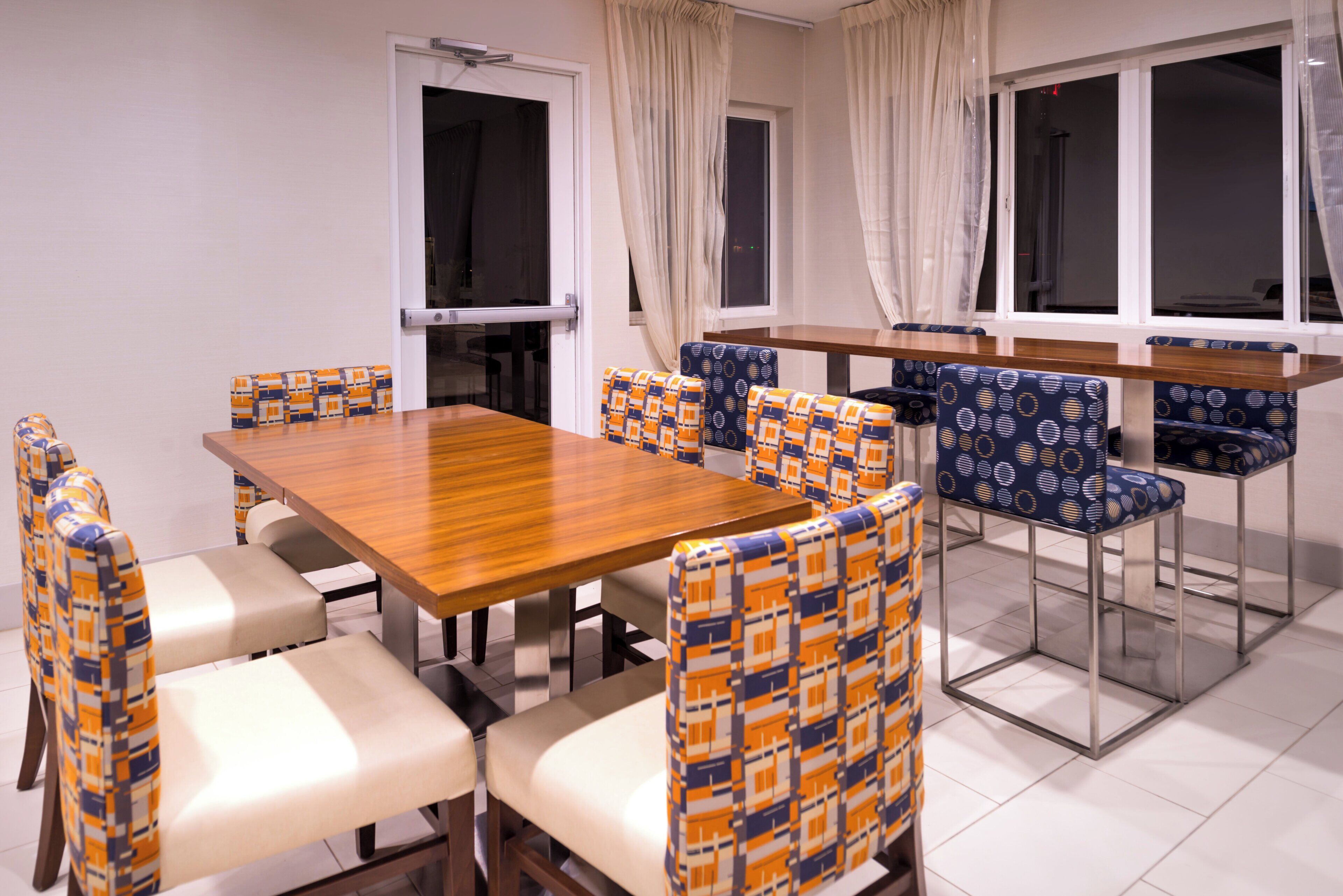 A dining area with a wooden table and chairs with patterned upholstery.
