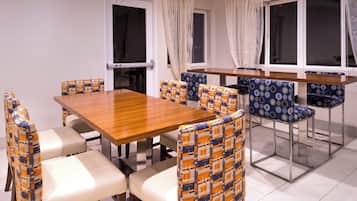 A dining area with a wooden table and chairs with patterned upholstery.