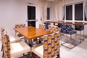 Un comedor con mesa y sillas de madera tapizadas con un estampado.
