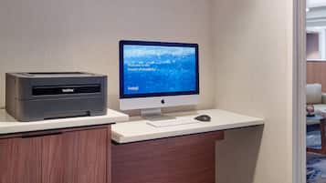 A Brother printer and an Apple desktop computer on a desk with a keyboard and mouse.