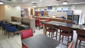 A modern restaurant with seating areas, a counter with food options, and a self-service beverage station.