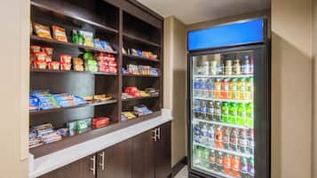 A self-service snack and drink vending area with various packaged snacks and a selection of bottled beverages.