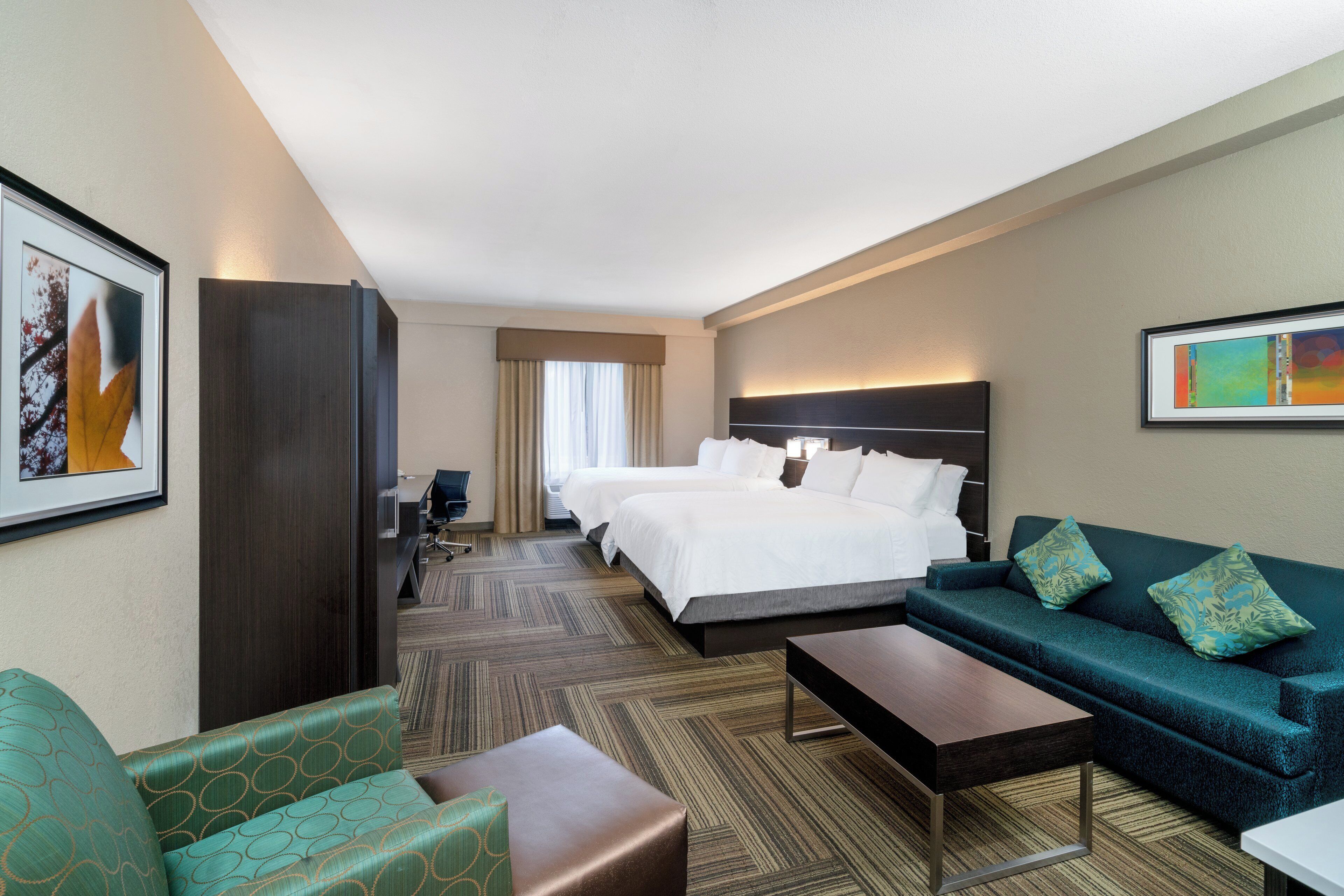 Una habitación de hotel con una cama grande, un sofá, un escritorio y una silla.