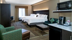 A hotel room with two beds, a sofa, a coffee machine, and a microwave.