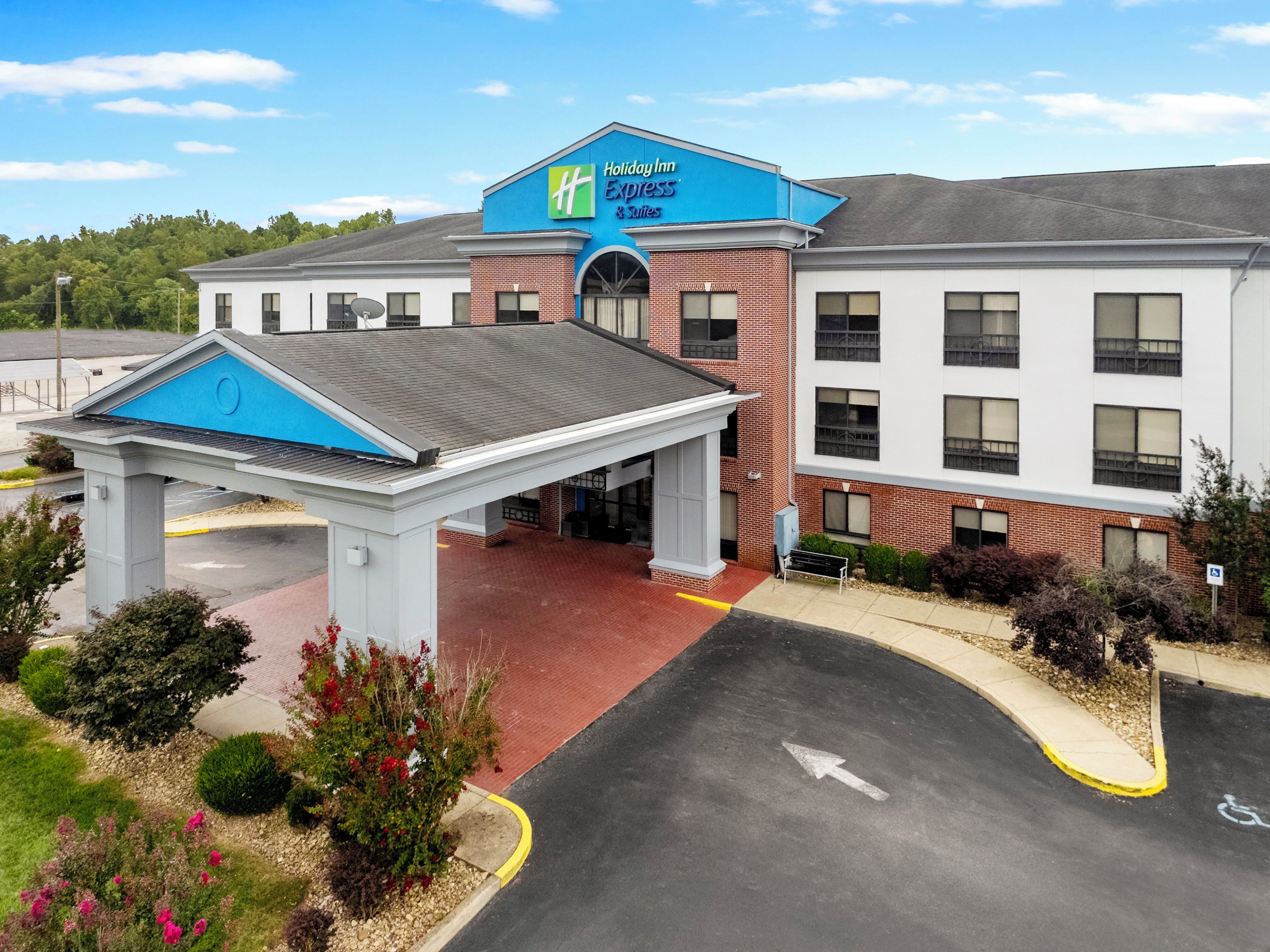A Holiday Inn Express & Suites building with a covered entrance and a parking lot.