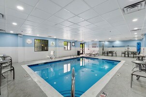 Zona de piscina con socorrista de servicio, elevador de piscina y sillas de descanso.