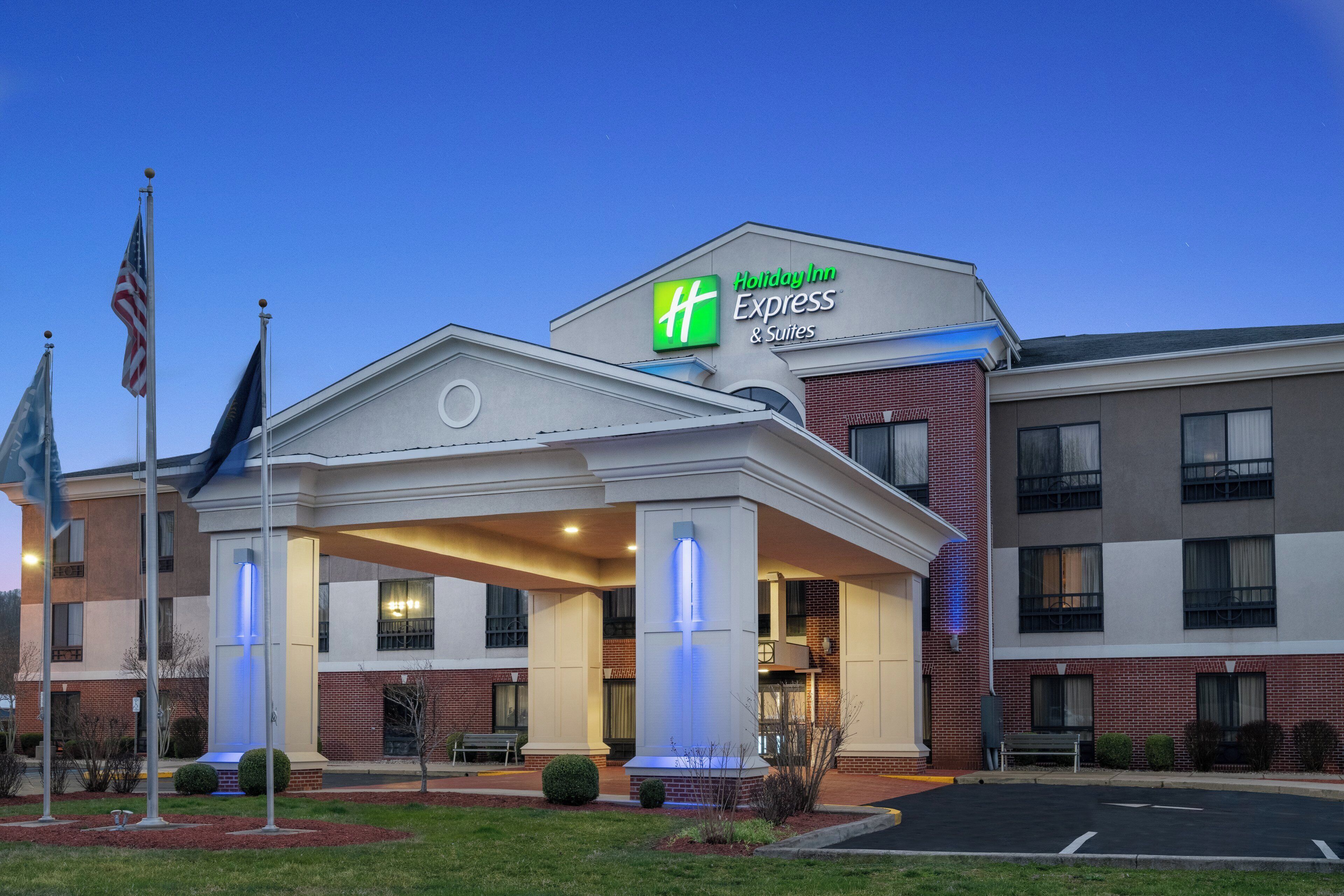 Ein Holiday Inn Express & Suites Gebäude mit überdachter Eingangspartei und einer Ziegel Fassade.