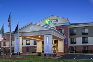 A Holiday Inn Express & Suites building with a covered entrance and a brick facade.