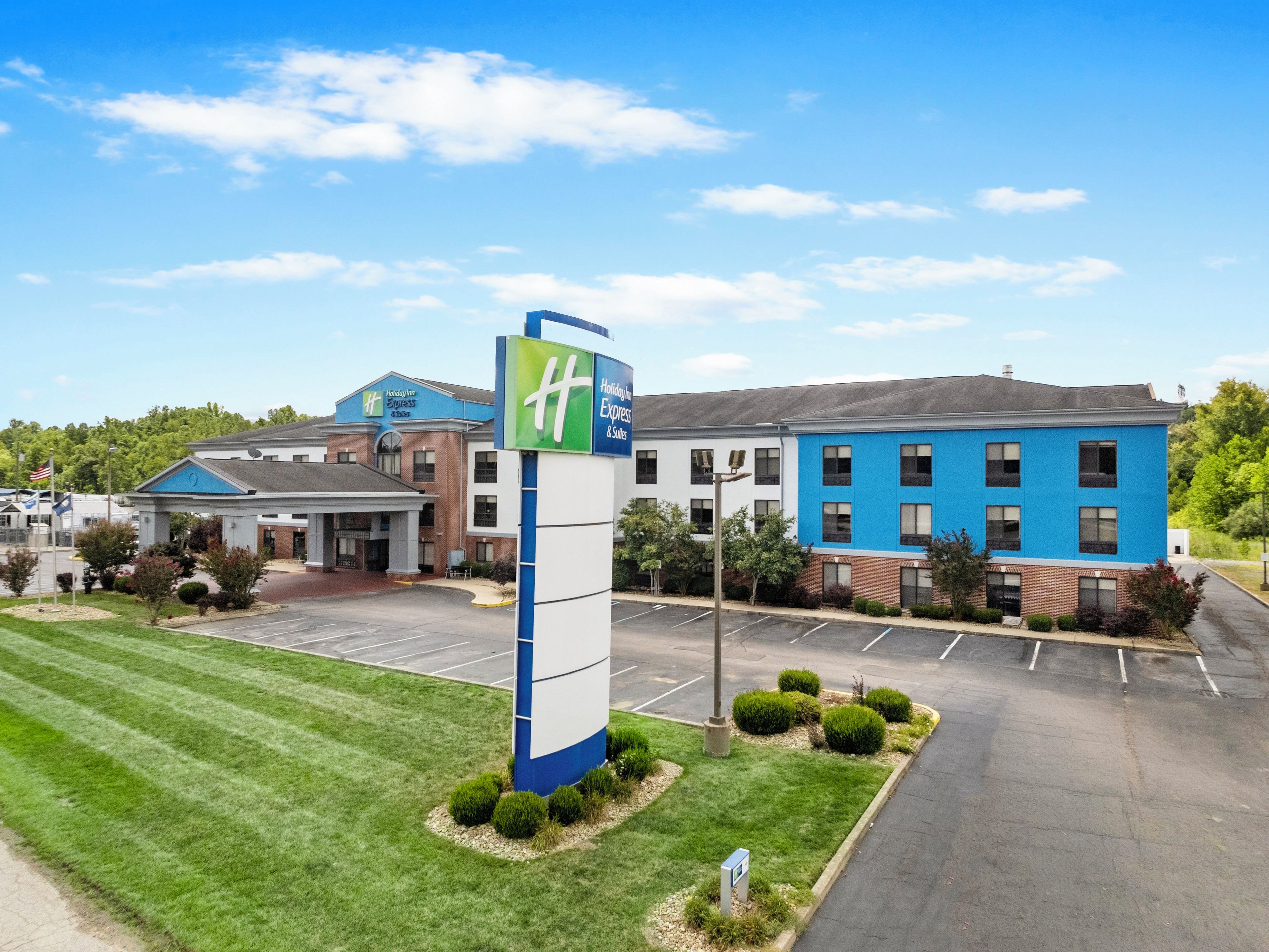 Et Holiday Inn Express hotel med parkeringsplads og græsplæne.